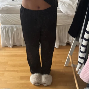 Svarta pyjamasbyxor med spetskant - Säljer ett par svarta pyjamasbyxor med fin spetskant längst ner vid bensluten. Byxorna har en lös passform och resår i midjan. 