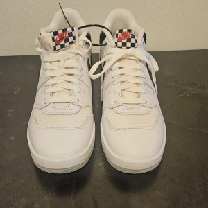 Nike sneakers med schackrutigt märke - Säljer oanvända Nike sneakers, ny pris 1649 kr.  Köparen står för fraktkostnad som tillkommer efter köp.
