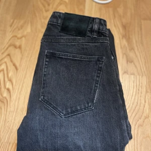 Svarta jeans från Neuw - Säljer ett par svarta jeansbyxor från Neuw med klassisk design och raka ben. Jeansen har normal passform och är tillverkade i ett slitstarkt denimtyg. Perfekta för dig som gillar en stilren look
