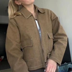 Beige mockajacka med dragkedja  - Helt slutsåld jacka från NAKD. Helt oanvänd och säljer pga att jag köpte fler storlekar. Storlek 36 i fuskmocka! Nypris 1000kr