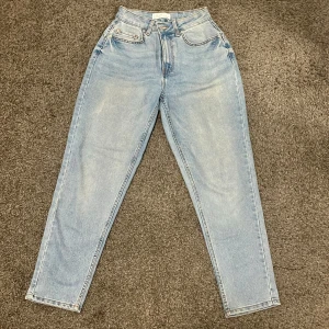 Primark ljusblå jeansbyxor (med normal passform) - Säljer ett par klassiska ljusblå jeansbyxor från Primark med fem fickor och hög midja. Jeansen har raka ben och stängs med dragkedja och knapp framtill. Perfekta till vardags och enkla att matcha med olika toppar👖👚🦋