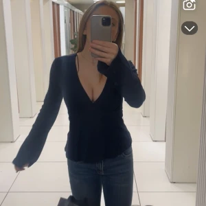 Mörk blå v-ringad topp - Säljer en mörk blå långärmad topp med djup v-ringning och figurnära passform. Toppen har långa ärmar och är tillverkad i ett mjukt, stretchigt material som sitter snyggt på kroppen. Perfekt att styla med jeans eller kjol. Säljer den eftersom jag inte använder den! Använd cirka 8 gånger bara 💞 pris kan diskuteras!!