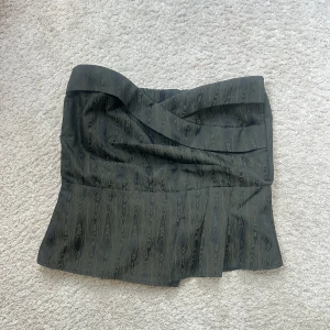 Bandeutopp  - Säljer denna gröna bandeutoppen från Copenhagen Muse med mönster och draperad framsida. Toppen har smockad rygg och dragkedja bak! Skriv vid frågor eller funderingar