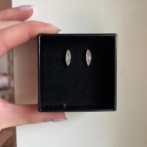 Örhängen - Superfina silvriga örhängen från Dyrberg/Kern💕De är ovala och har en vit/genomskinlig kristall i mitten. Båda örhängena och plupparna har ingraverat D/K. De har aldrig blivit använda och har därmed inga defekter. Skriv gärna vid frågor eller funderingar☺️