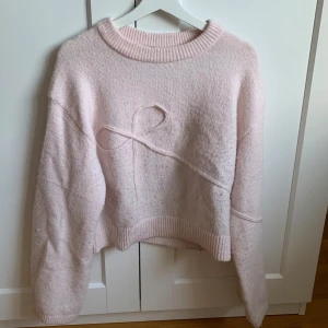 Ljusrosa stickad tröja med rosettdetalj - Rosa tröja med rosett från hm