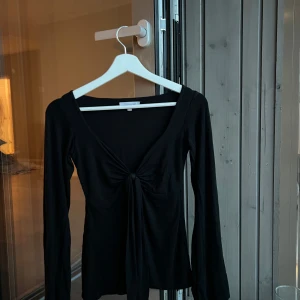 DesignBy Si tröja i svart - Säljer min fina topp från DesignBy Si som tyvärr inte kommer till användning.  Storlek XS/S, tröjan är normal i storleken och är endast testad. Den är lite skrynklig då den legat i en flyttkartong men det åtgärdas lätt med att stryka den. Nypris: 393 kr