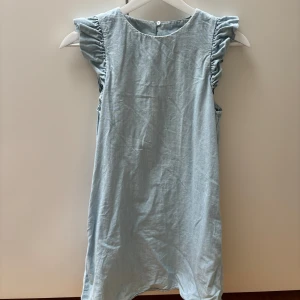 Jeansklänning med volang - Jeansklänning från Mango med volangdetaljer på axlarna. 