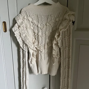 Vit spetsstickad tröja från Zara - Supersöt vit stickad tröja från Zara med volangdetaljer och spets längs ärmar och framstycke. Tröjan har lång ärm och är tillverkad i ett mjukt material med fina virkade mönster. Är i storlek M men passar även S. 💘