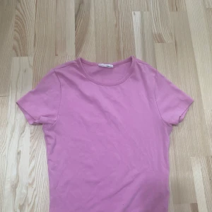 Rosa t-shirt från Gina Tricot -  Kortärmad rosa topp från Gina Tricot i storlek S. Normal i storlek och i fint skick. Består av 94 % bomull – mjuk och bekväm mot huden. Ett perfekt basplagg i garderoben! Säljer då den inte kommer till nån användning hos mig :(