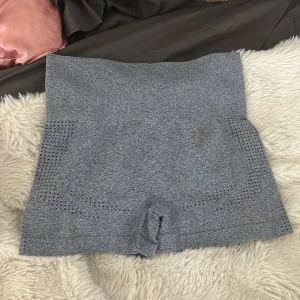 Grå sömlösa träningstights-shorts - Grå sömlösa shorts med hög midja och ventilerande meshdetaljer på sidorna. Perfekta för träning eller gymmet, med stretchigt material som sitter tight och bekvämt.