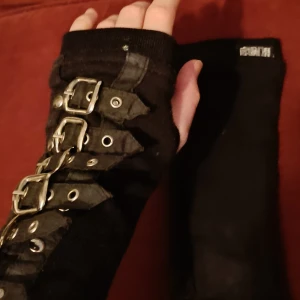 Emo handskar med spännen från Poizen Industries - Säljer ett par svarta handskar från Poizen Industries med flera spännen. Handskarna är långa och har en alternativ stil.