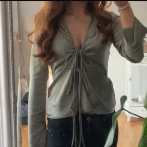 Zara topp Grå/grön med knytband - Snygg grå/grön fest topp med djup v-ringning och långa ärmar. Toppen har flera knytband framtill. Mycket bra skick perfekt nu till sommaren