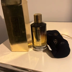 Oud Vanille Eau de Parfum från Mancera - Lyxig parfymflaska i guld från Mancera med doften Oud Vanille. Flaskan har en elegant rund form med guldfärgat lock och etikett. Kommer med originalförpackning i guld och en svart tygpåse med dragsko och gulddetaljer. Pris kan diskuteras