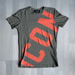 Dsquared2 ”ICON” T-Shirt - Army green - Olivgrön T-Shirt från Dsquared2 med ICON tryck i orange. Storlek: L Passar S. Tveka inte, hör av er vid funderingar 😄 