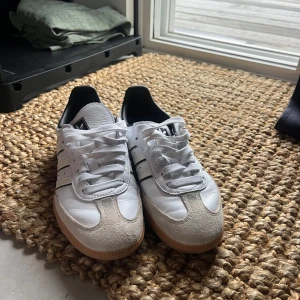 Adidas Samba vita sneakers - Skit snygga Adidas Samba sneakers i vitt skinn med svarta detaljer och gummisula. Använda enbart en gång 