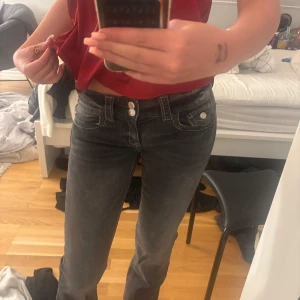 Svarta bootcut jeans med vita sömmar - Säljer ett par svarta bootcut jeans med tydliga vita sömmar och dubbla knappar i midjan. Jeansen har klassiska fickor fram och bak och en snygg tvättad look. Perfekta för dig som gillar en tidlös stil med lite edge. från gina young storlek 152. jag är 170 lång och dom är inte för korta