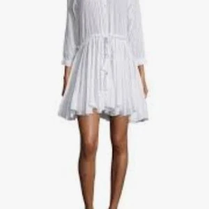 Vit kortklänning från Zadig & Voltaire strl S - Säljer en luftig och lätt vit kortklänning från Zadig & Voltaire. Klänningen har knappar framtill, trekvartsärm och knyt i midjan för en justerbar passform. Perfekt för varma dagar och har en avslappnad, feminin siluett.