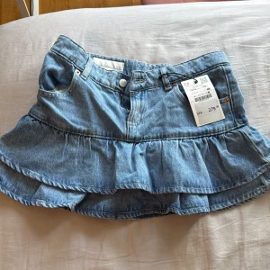 Jeanskjol med volang - Helt ny jeanskjol med volanger med lappen kvar. Säljer då den var för liten!!