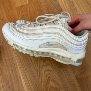 Nike Air Max 97 vita sneakers - Vita Nike Air Max 97 sneakers.   Storlek 37,5 men känns mer som en 37 enligt mig.  Bra skick men använda, skulle må bra av att få bli tvättade. Skulle de tvättas med klorin skulle jag gissa att det blir väldigt vita och rena.