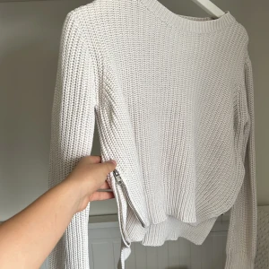 Beige stickad tröja med dragkedjedetalj från H&M - Säljer en beige stickad tröja från H&M med lång ärm och cool dragkedjedetalj på sidan. Tröjan har en rund halsringning och är perfekt för lager-på-lager-stil. Snygg och enkel att matcha till det mesta! Pris går att diskutera 