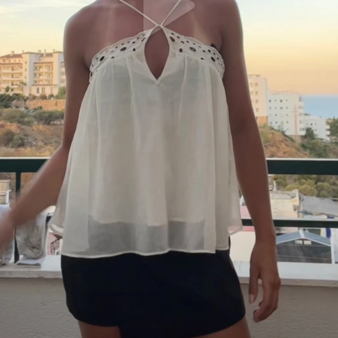 Vit ärmlös linnetopp med broderade detaljer