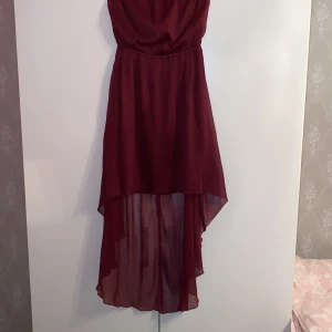 Vinröd klänning från Gina Tricot - Säljer en vinröd klänning från Gina Tricot med asymmetrisk fåll och lätt, flowigt tyg. Klänningen är ärmlös samt axkelbands lös och har en längre bakdel vilket ger en snygg siluett. Perfekt för dig som vill sticka ut med en elegant look. Säljer denna vackra klänning då jag inte använder den💕