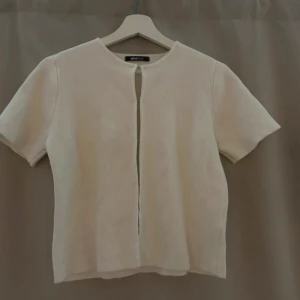 Vit kortärmad blus - Säljer en stilren vit blus från Gina med korta ärmar med en dekorativ öppning framtill som ger en snygg touch. Aldrig använd 🌟