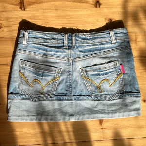 Ljusblå jeanskjol med broderade fickor - Jättesnygg minikjol från just play, men för liten på mig. Står strl 27 men skulle säga att den är 24-25! Saknas en knapp och några diamanter på fickorna, därav priset. 💗34cm tvärsöver