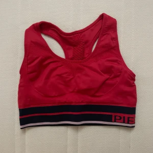 Röd sport top - En röd topp som är ganska gammal inte andvänd på långe och kommer inte till andvändning. Vet ej vart den är ifrån 