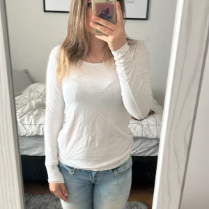 Vit långärmad tröja från Basic You - Säljer en enkel och stilren vit långärmad tröja från Basic You i ekologisk bomull. Perfekt basplagg med rund hals och mjukt material. Passar till det mesta och är superbekväm att ha på sig.
