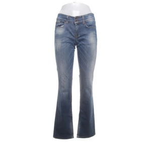Blå bootcut jeans med slitningar - Säljer ett par klassiska blå jeans med bootcut passform och diskreta slitningar framtill. Ifrån salsa