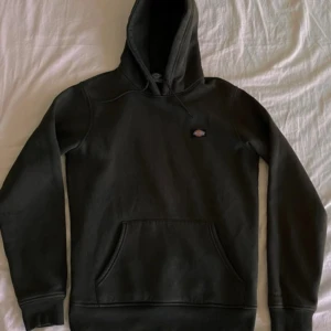 Mörkgrön hoodie från Dickies - Säljer en mörkgrön hoodie från Dickies i storlek XS. Klassisk modell med huva och magficka, perfekt för en avslappnad stil. Mjuk insida och diskret logga på bröstet. Passar till det mesta och är riktigt bekväm.