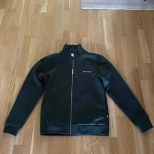 Mörk grönt tracksuit set från Les Deux - Tracksuit set från Les Deux, tröja och byxor. Knappt använt och inköpt för drygt 1 år sedan Alltså nästan som nytt Storlek M på tröja  Storlek L på byxa