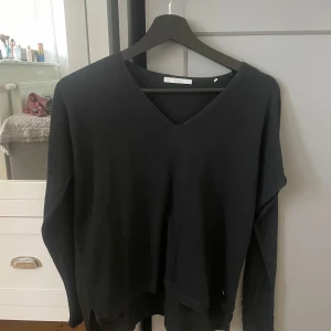 Svart v-ringad tröja  - En svart v-ringad tröja.Tröjan har lång ärm och är i ett mjukt, tunt material som passar perfekt till lager-på-lager. Enkel och stilren design som funkar till det mesta.