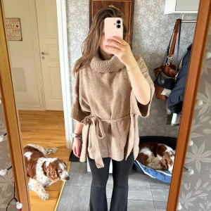 Beige stickad polotröja med knytning - Säljer en beige stickad polotröja från H&M i storlek XS. Tröjan har bred polokrage, knytning imidjan och korta, vida ärmar. Väldigt mjuk och skön. 