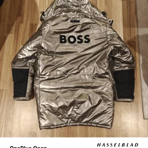 Limited Edition Jacka från BOSS  - Säljer en riktigt cool Limited Edition vinterjacka från BOSS med RECCO-reflektor. Jackan har alltså ett inbyggt system som gör att den kan spåras om du hamnar i nödsituation. Jackan är väldigt varm. Den har även hängslor vilket gör att du kan ha den hängandes på ryggen som på afterski. Jackan är i bra skick, inga hål eller större slitage. Nu skicka var 8000 kr för 3 år sen. Vill du vara en lysande stjärna i backen så är detta jackan för dig.