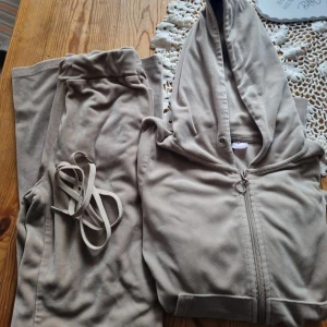 Beige mjukisbyxor med snörning - Säljer ett par beige mjukisbyxor i mjukt och skönt material, perfekta för chill dagar. Byxorna har resår i midjan och medföljande snörning för extra komfort. Passar dig som gillar avslappnad stil och vill ha något riktigt bekvämt.