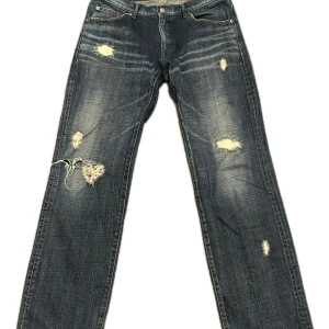 Mörkblå distressed jeans från Tete Homme - Säljer ett par blå jeans från Tete Homme med coola slitningar och distressed detaljer på benen. Jeansen har raka ben och en mörk tvätt med ljusare partier. Köpta i New York. Det är ett japanskt märke och jag tror storleken är L men sitter lite mindre. Väldigt gott skick. Kan ta reda på mått om det behövs. Pris kan diskuteras 