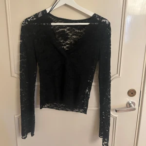 Svart spetstopp - Superfin spetstopp från Ginatricot, perfekt till fest . Använd vid några enstaka tillfällen men används inte längre. Vad jag kan se så är den i fint skick, (kan vara någon tråd eller liknande som jag missat och då kan man enkelt klippa bort det)🥰