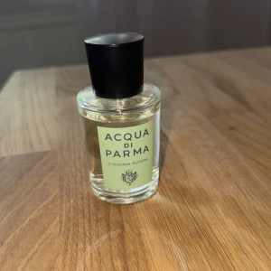 Acqua di Parma Colonia Futura 50 ml - Fräsch parfym från Acqua di Parma, Colonia Futura. Flaskan är cylindrisk i transparent glas med en ljusgrön etikett och svart plastkork. Innehållet är ljusgult och ger en elegant vibe. Perfekt för dig som gillar klassiska och stilrena dofter. Skulle säga att det finns cirka 45 ml kvar :)