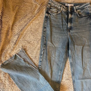 Ljusblå jeans från Zara, strl 36 - Ljusa jeans med hög midja och utsvängda ben och slitsar. Storlek 36.
