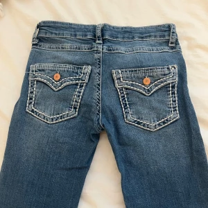 Jeans från ginatricot  - Säljer ett par blå med vita sömmar med fina fickor bak. 