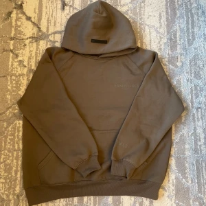 Brun/grå Essentials Fear of God hoodie - Endast använd runt 3 gånger och är i jätte bra skick ser i princip ny ut vid fler frågor är det bara att skriva!