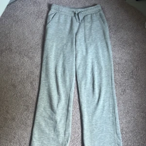 Grå mjukisbyxor från lager 157 - Snygga grå mjukisbyxor från 157 med normal passform och raka ben. Byxorna har elastisk midja med snörning, två sidofickor fram och två bakfickor. Perfekta för chill dagar eller när du vill vara extra bekväm.