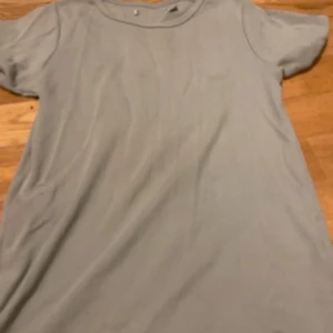 Ljusgrön ribbad kortärmad T-shirt - Säljer en enkel och stilren ljusgrön t-shirt med ribbad struktur. Klänningen har rund hals och korta ärmar, perfekt för dig som gillar minimalistisk och clean look. Materialet känns mjukt och bekvämt mot huden.