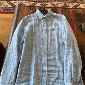 Ljusblå linneskjorta från Morris - Säljer en ljusblå skjorta i linne från Morris. Köpt för cirka 1200 kr. Den är använd ett fåtal gånger så fortfarande i riktigt fint skick. Skriv privat för fler frågor! 