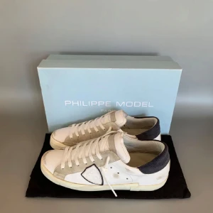 Philippe Models (helt nya) - Snygga vita sneakers från Philippe Model med grå och svarta detaljer. Skorna har en unik stil med slitningar. Perfekta för en stilren look. Skorna är helt nya bara använda endast 5 gånger. Dushbag box o allt ingår! Hör av dig vid funderingar eller andra frågor. Pris kan diskuteras vid snabb affär!!