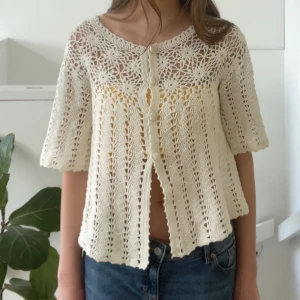 Vit virkad kofta Indiska - Supersöt virkad kofta från Indiska som är så fin till sommaren. Den är i storlek M men passar dig som är i storlek S-XS också! Vet inte vad den kostade ursprungligen.