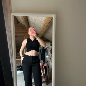 Svart ribbad croppad linnetopp från BikBok - Säljer en svart croppad topp från BikBok i ribbat material. Toppen är ärmlös med en v-ringad hals och har en tight passform. Den är köpt second hand men aldrig använd hos mig🥰 