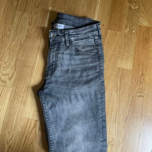 Grå slim jeans från Vaillent - Säljer ett par grå slim fit jeans från Vaillent. Jeansen har klassisk design, normal midja och stängs med dragkedja och knapp. Snygg tvättad  grå färg som passar till det mesta. Perfekta för dig som gillar en smalare passform. Sällant använd.